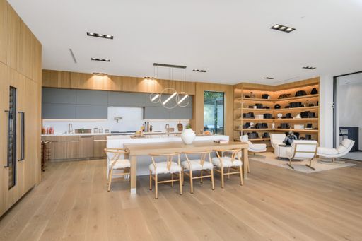 The wooden cabinets and bar in a kitchen with a table, chairs, and utensils.