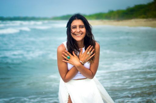 A young Hispanic female smiling and having fun on the beach