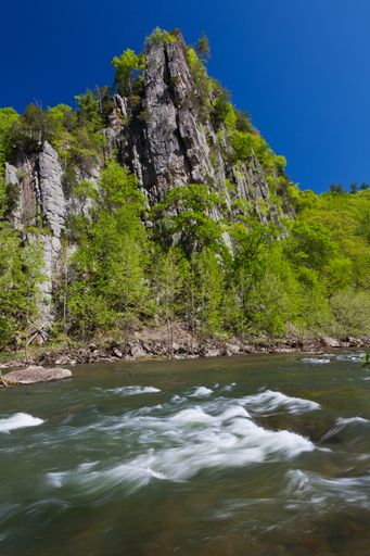 A vertical shot of Eagle Rock along the South Branch of the Potomac River in West Virginia in the spring under clear blue sky.