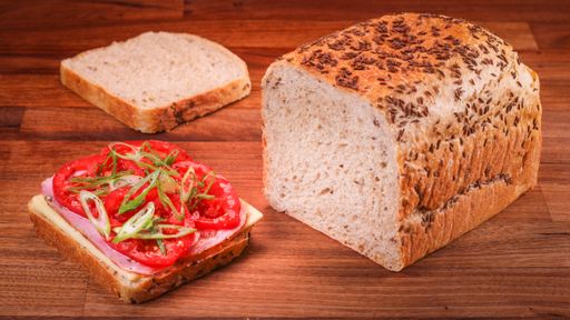A closeup shot of bread slices with a sandwich on a wooden table