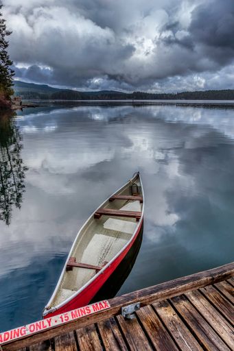 A canoe tied to the dock beside the Comox Lake boat launch. Comox Lake is a popular recreation spot in the Comox Valley, Vancouver Island, BC, Canada.