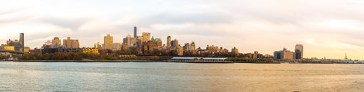 A cityscape at sunset with a beautiful sun setting in the background