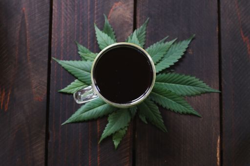 A closeup shot o cannabis, hemp, CBD or THC infused black coffee on dark wood background