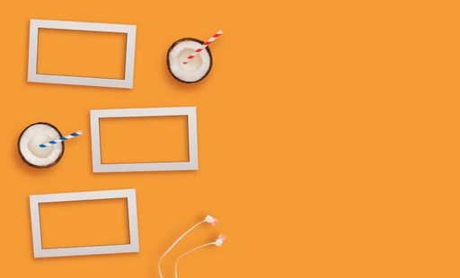 A top view of white blank frames with coconuts on a light orange surface.
