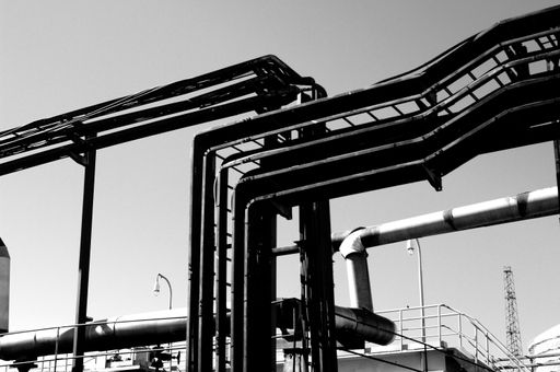 A grayscale shot of iron structures at the oil factory