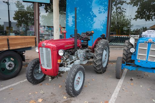Front view of an old red tractor parked on the street, it is a Massey Ferguson model 35