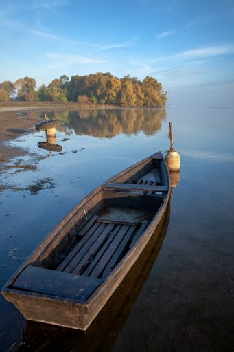 A village boat moored at the shore near dense forest