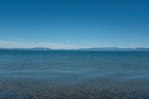 A wide shot of the Lake Tahoe, with mountains and blue clear sky in the background at California, USA