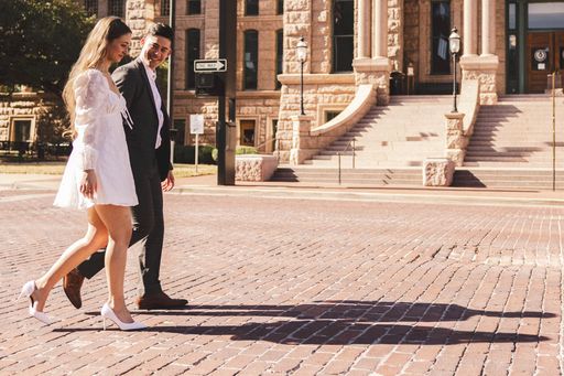 A couple strolling near a building on a city street