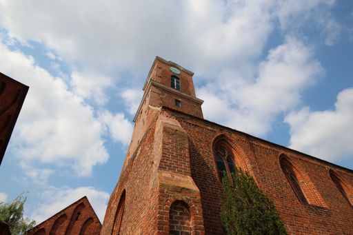 A low angle of high red tiled building with blue cloudy sky