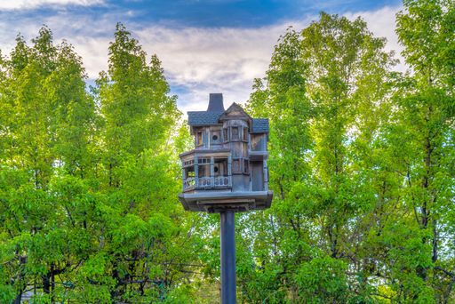 A big birdhouse in front of the trees