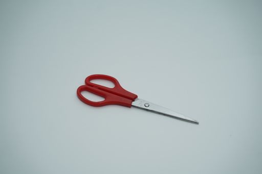 A top-view of red scissors placed on a flat surface