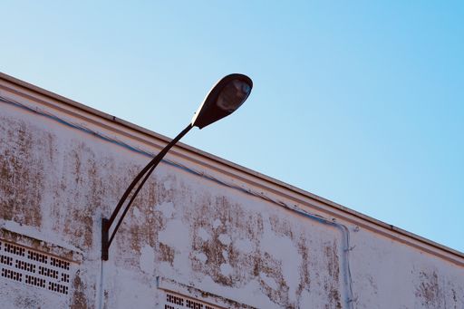 A low angle shot of a street lamp on an aged building
