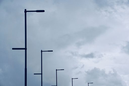 A low angle shot of lamp posts with gloomy sky in a backgrou