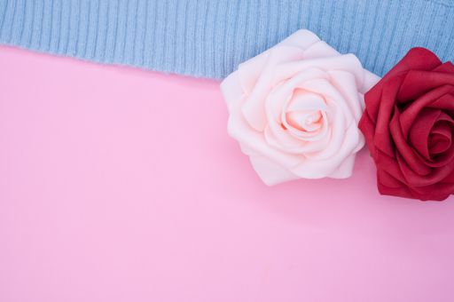 A closeup of the decorative artificial colorful roses on the blue fabric