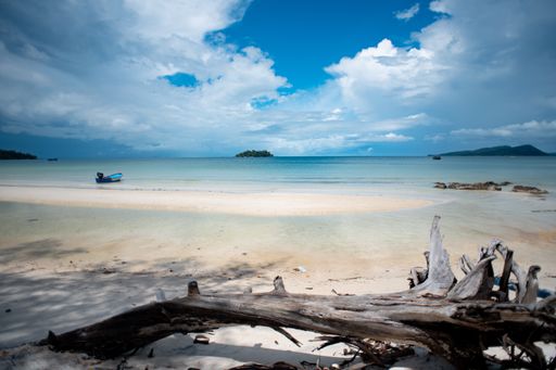 A boat anchored in the distance at a serene beach