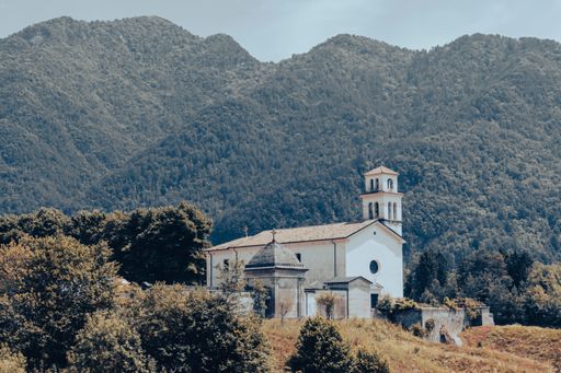 A white church surrounded by green dense forests in a mountainous area