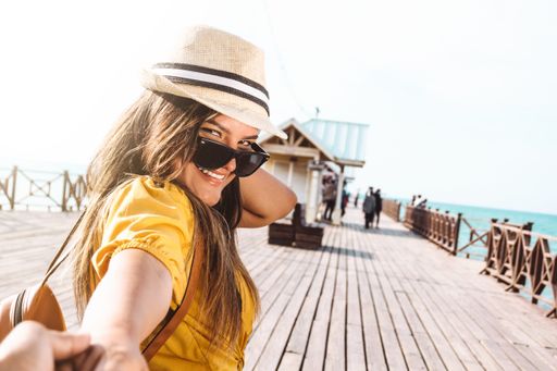 portrait of a Latin American traveler girl holding her partner by the hand walking forward. travel and couples concept.