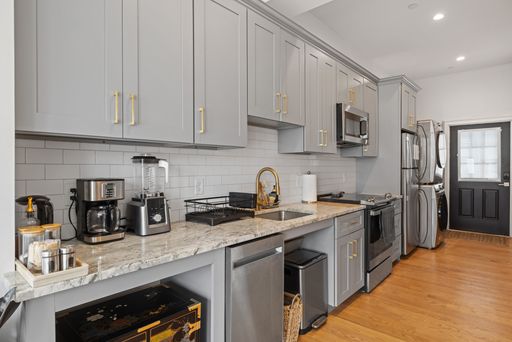 Kitchen interior with oven, sink, and fridge