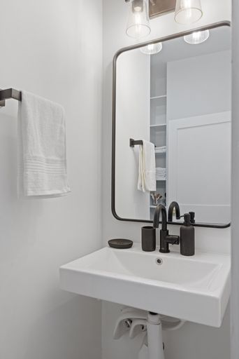 Bathroom sink with mirror and bottles on countertop