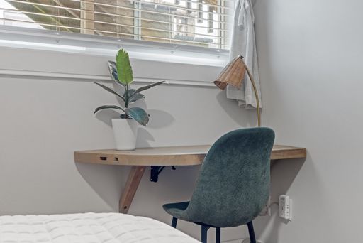 Bedroom with green chairs and small desk by bed
