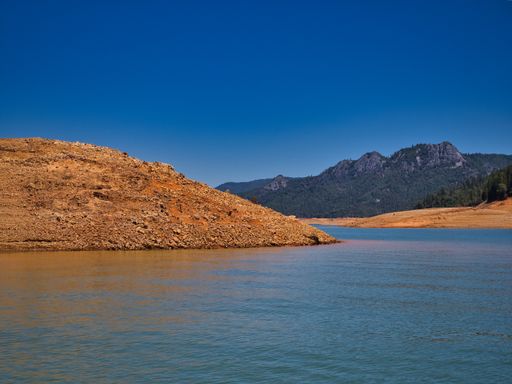 A beautiful lake Shasta surrounded by hills on a drought