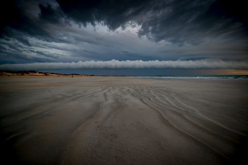 The Cable Beach surrounded by the sea under a cloudy sky during the sunset in Australia