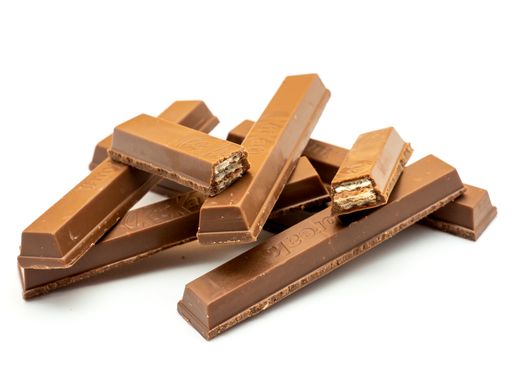Assorted chocolate pieces with some full and broken bars against a white background