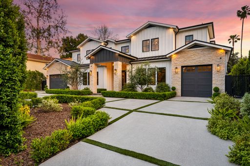 A house in a charming neighborhood with stunning sidewalk landscaping.