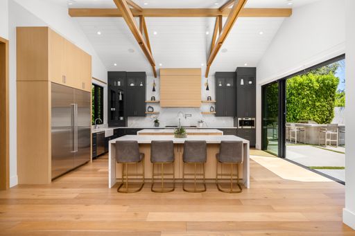 Spacious kitchen with a countertop and three bar stools