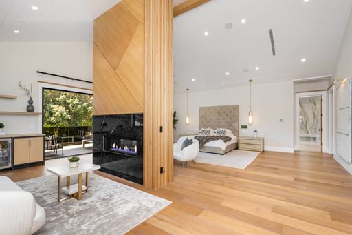 Cozy bedroom featuring a television and fireplace