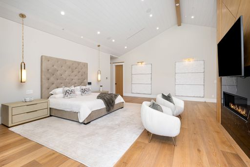 Contemporary bedroom with white furniture and hardwood accents
