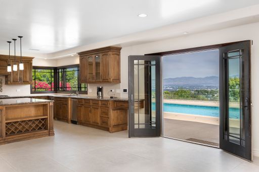 A modern kitchen with wooden cabinets and white tile flooring in Encino, California