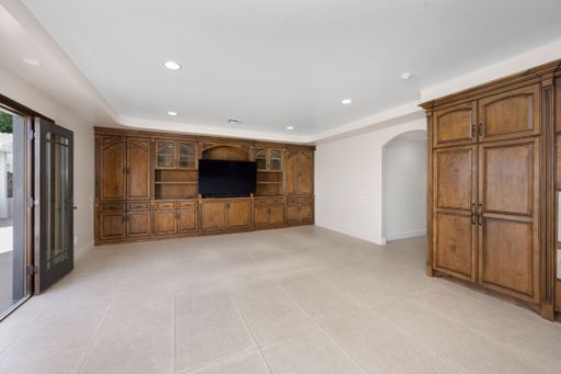 A minimalist living room interior with a spacious cabinet and television in Encino, California
