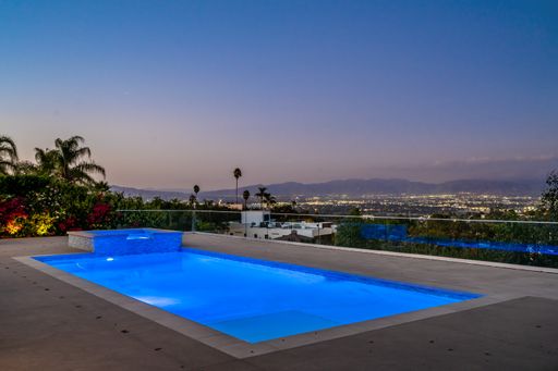 A brightly lit pool under a starry night sky in Encino, California
