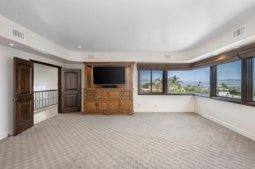 A bedroom with spacious windows and a wall-mounted TV in Encino, California