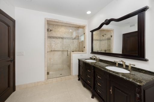 A spacious bathroom with dual sinks and a walk-in shower in Encino, California