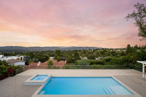 An outdoor swimming pool at sunset with vibrant sky in Encino, California