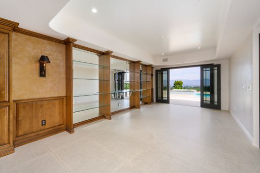 A modern room with glass wall, wooden shelves, and white tiles in Encino, California