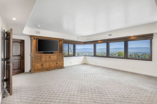 A  spacious living room with big windows and large TV screen in Encino, California
