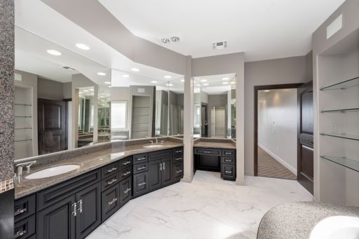 A luxurious bathroom with marble countertop and oversized mirrors in Encino, California