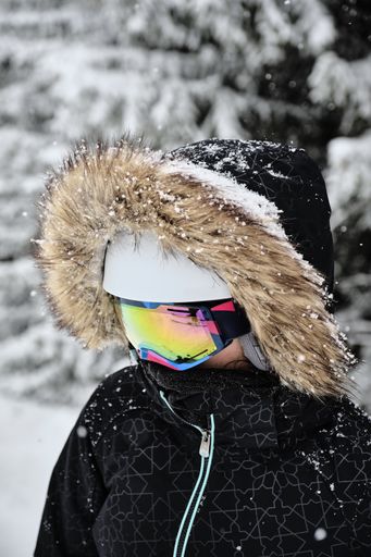 A closeup shot of a skier wearing fur hooded jacket and goggles at Alpe d Huez ski resort, France