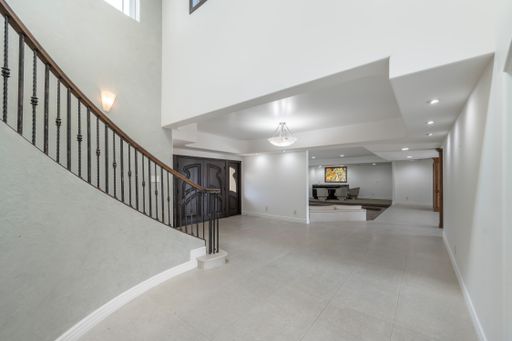 The interior of home hallway with elegant chandelier and spacious layout in California