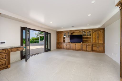 A kitchen with wooden cabinets and flat screen TV in a cozy room, California