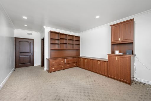 An interior scene featuring wooden cabinets and carpeted floors in California