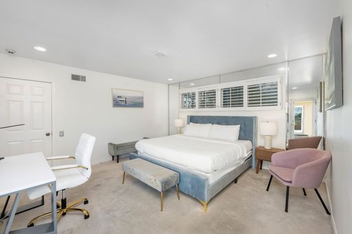 A spacious master bedroom with a bed, desk, and dressing area in Hidden Hills, CA