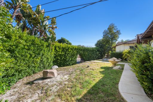 A spacious backyard with bushes and rocks in Hidden Hills, CA
