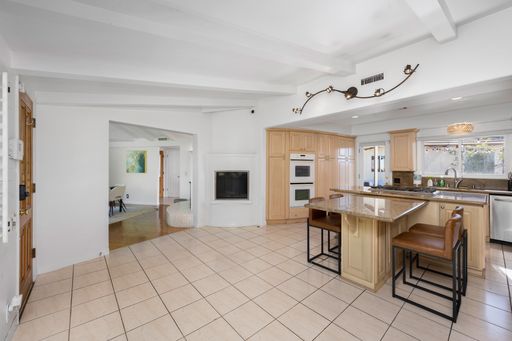 A spacious contemporary kitchen with central island and bar stools in Hidden Hills, CA