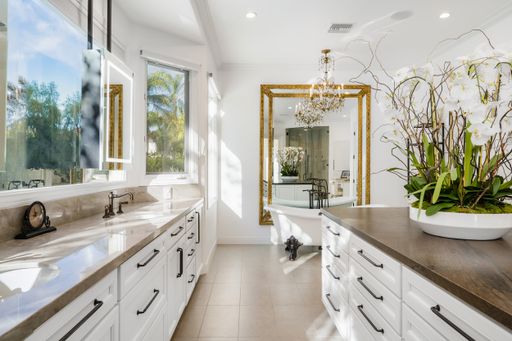 Bathroom with white cabinets and a spacious mirror
