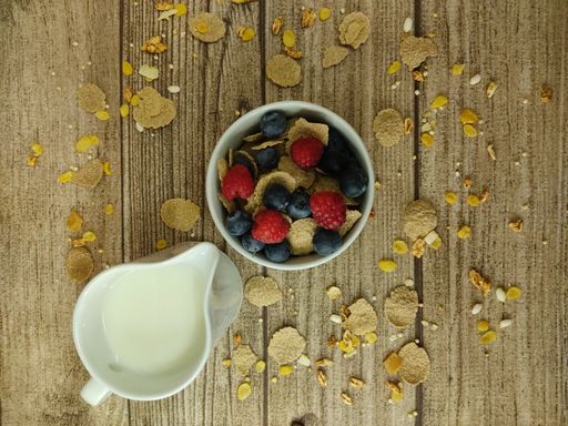 A top view of a bowl of fresh and delicious Granola and milk on a wooden table